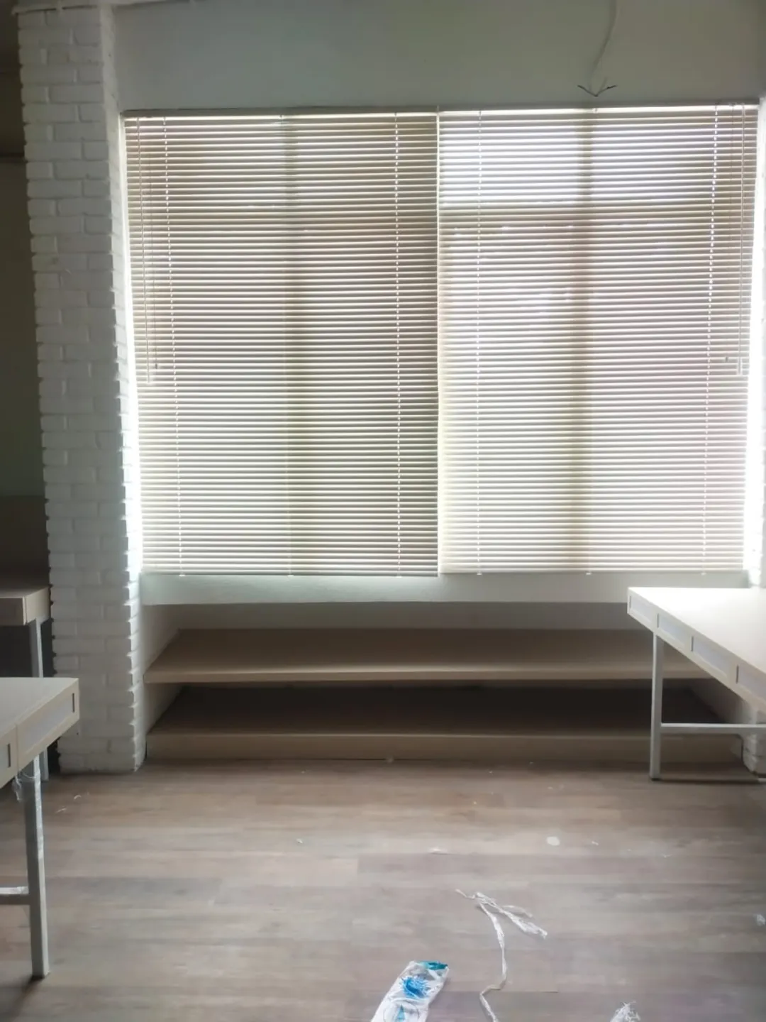 Horizontal blind putih terpasang pada dua jendela lebar